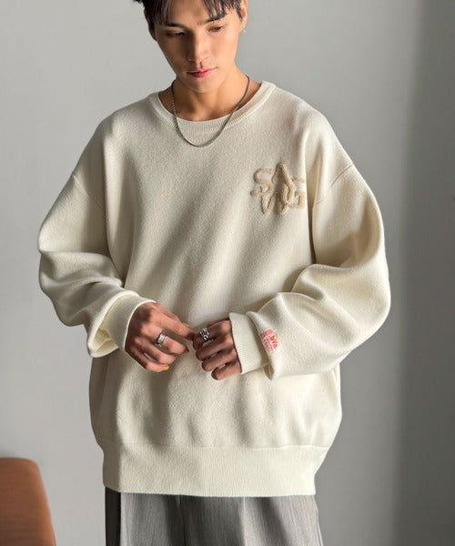 《JaVaジャバコラボ》立体編みで飾る個性。サガラ刺繍風ロゴオーバーサイズニット jm1050332